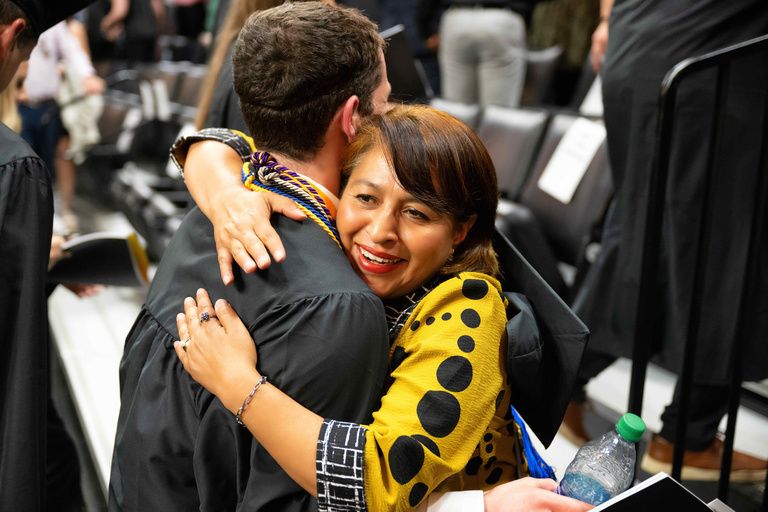 Gabriela Rivera hugs student graduating