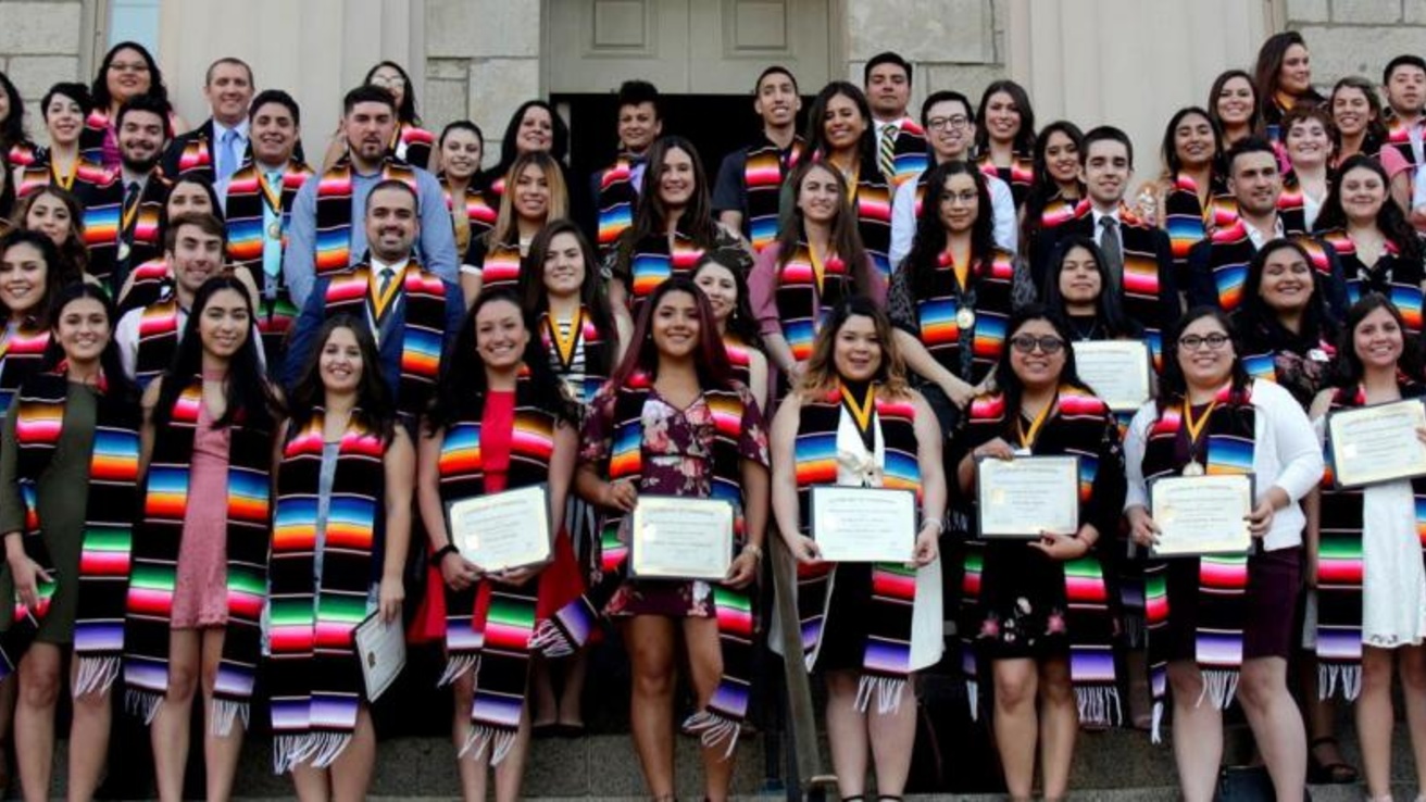 Group of graduating students posing with their latinx shawls